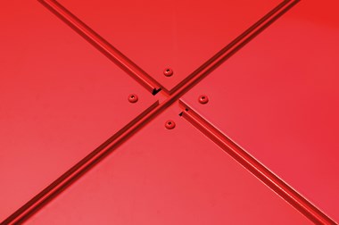 Square red façade panels mounted in a diagonal pattern